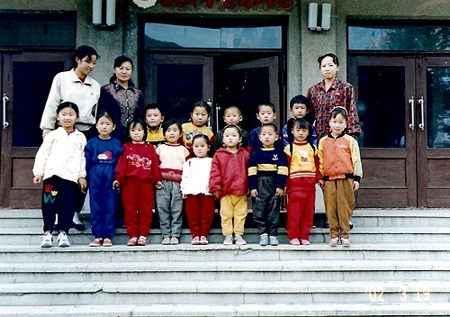 빵을 보급받고 있는 북한 무산유치원 선생님과 아이들 